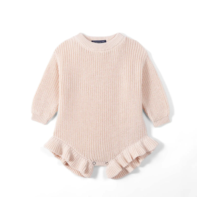Beige chunky knit baby romper flat lay with ribbed cuffs and ruffled leg openings