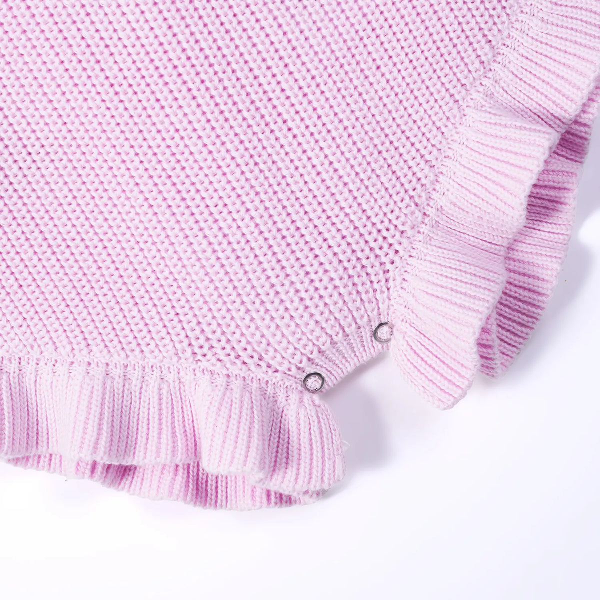 Macro view of ribbed ruffle trim and metal snap buttons on lilac romper leg