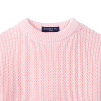 Close-up of pink chunky knit texture and navy label reading SWaddle AN 3-6M inside collar