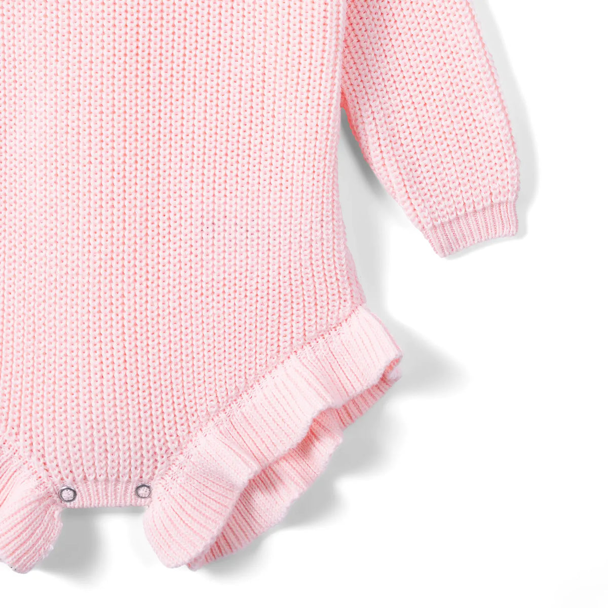 Light pink romper detail highlighting garter stitch fabric, ribbed cuff, and metal snap fasteners