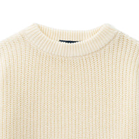 Close-up of cream baby sweater neckline showing tight-gauge vertical knit texture and stitched back label