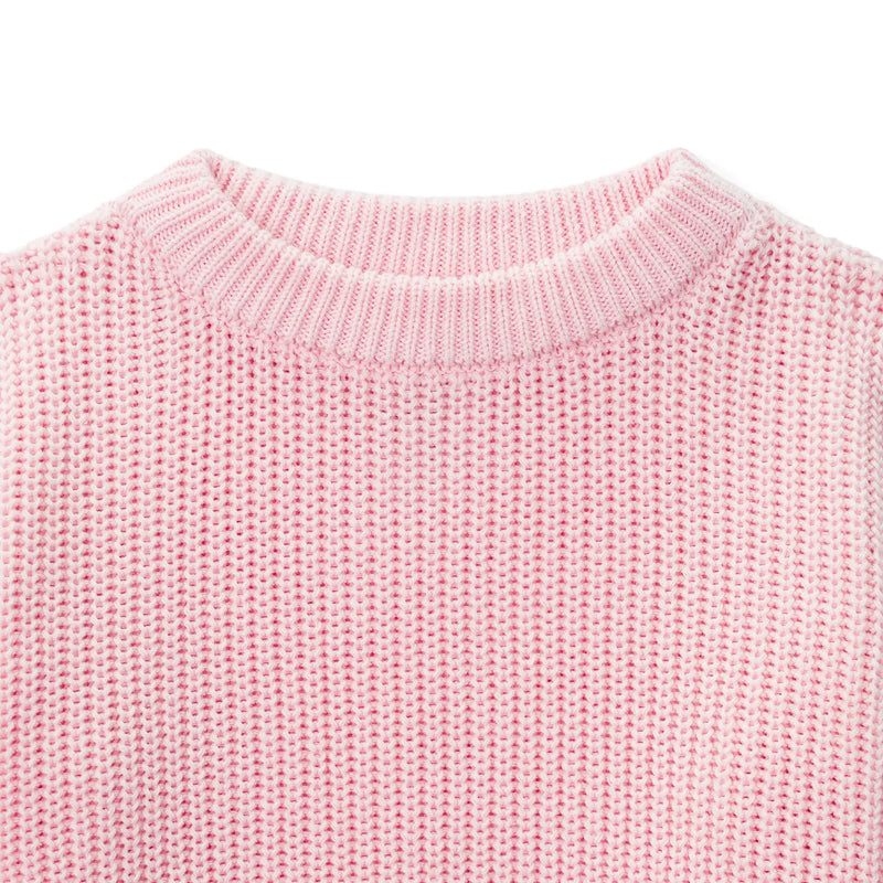 Close-up of pastel pink garter stitch knit texture and ribbed crew neck collar detail