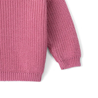 Side detail of rose pink baby sweater sleeve attachment and ribbed cuff on white background