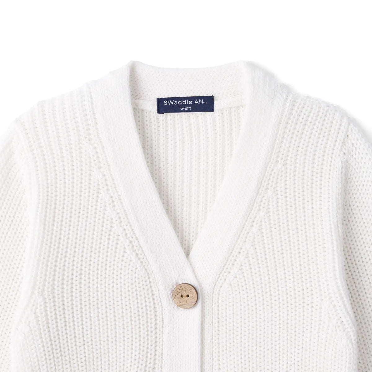 Close-up of white ribbed knit neckline showing top wooden button and navy SWaddle AN size tag