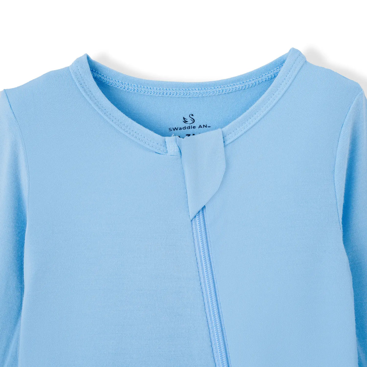 Close-up of ribbed neckline on blue infant sleepwear featuring fabric safety tab over zipper top and swan logo