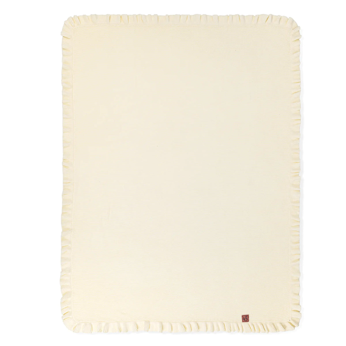 Flat-lay of cream waffle knit nursery blanket showing full rectangular shape and ruffled border