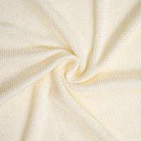 High-res macro of cream fabric swirls highlighting plush waffle-weave stitch pattern