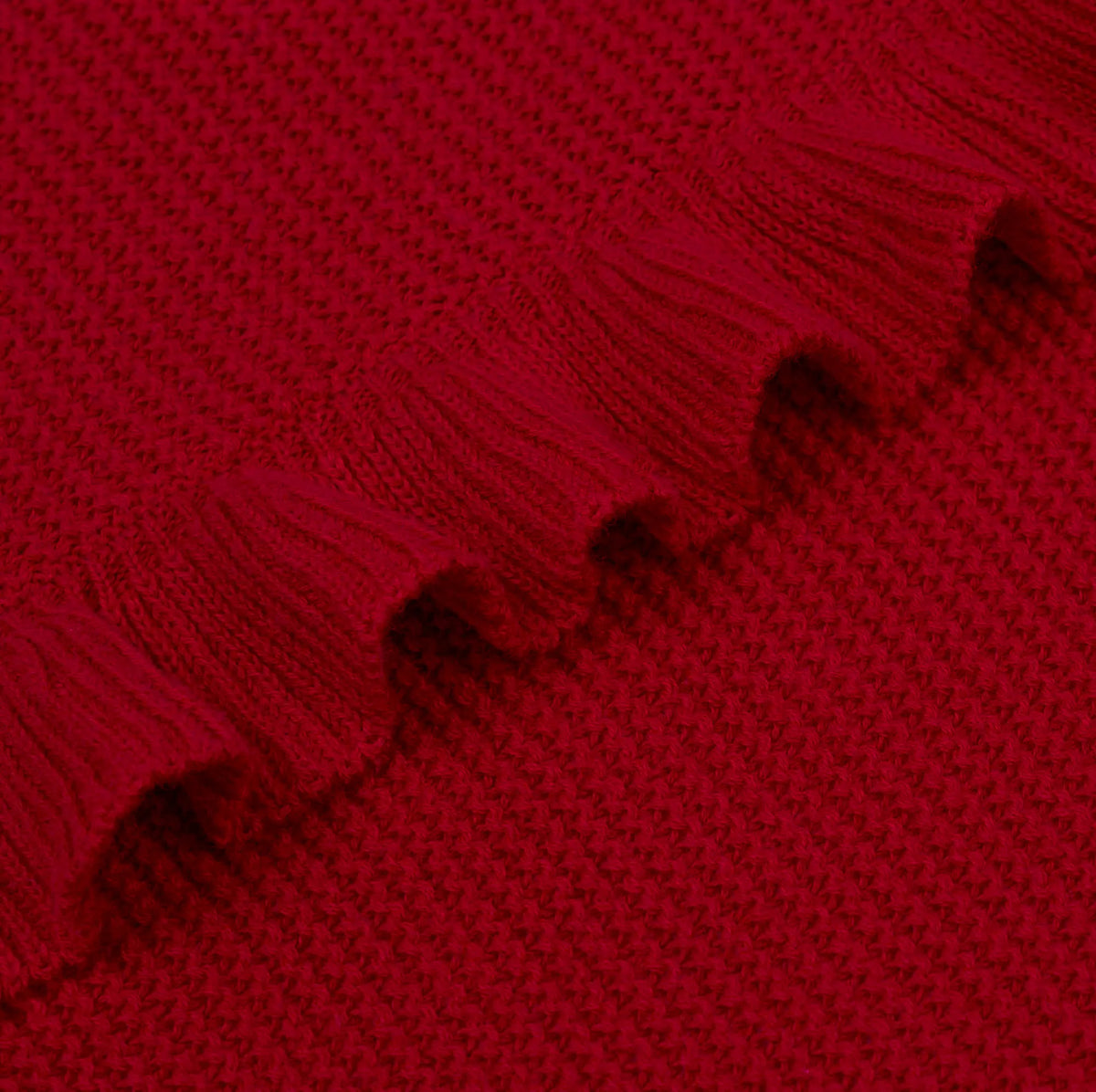 Macro close-up of red knitted fabric weave and detailed gathered ruffled trim construction