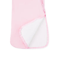 Folded bottom corner of pink sleep sack revealing smooth white inner lining and pink piping hem