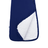 Open navy sleep sack revealing white quilted inner lining insulation