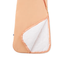 Open zipper showing white quilted lining in peach sack