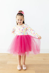 Girl wearing Sweetheart Long Sleeve Tutu Dress with a multicolor heart-pattern top and pink fluffy tulle skirt.