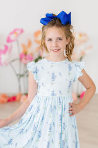 Texas Bluebonnets Flutter Sleeve Twirl Dress for Girls worn by a smiling girl with a large blue bow.