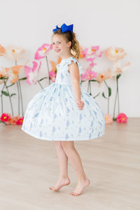 Texas Bluebonnets Flutter Sleeve Twirl Dress for Girls: girl twirling in a light blue floral dress with a blue bow.