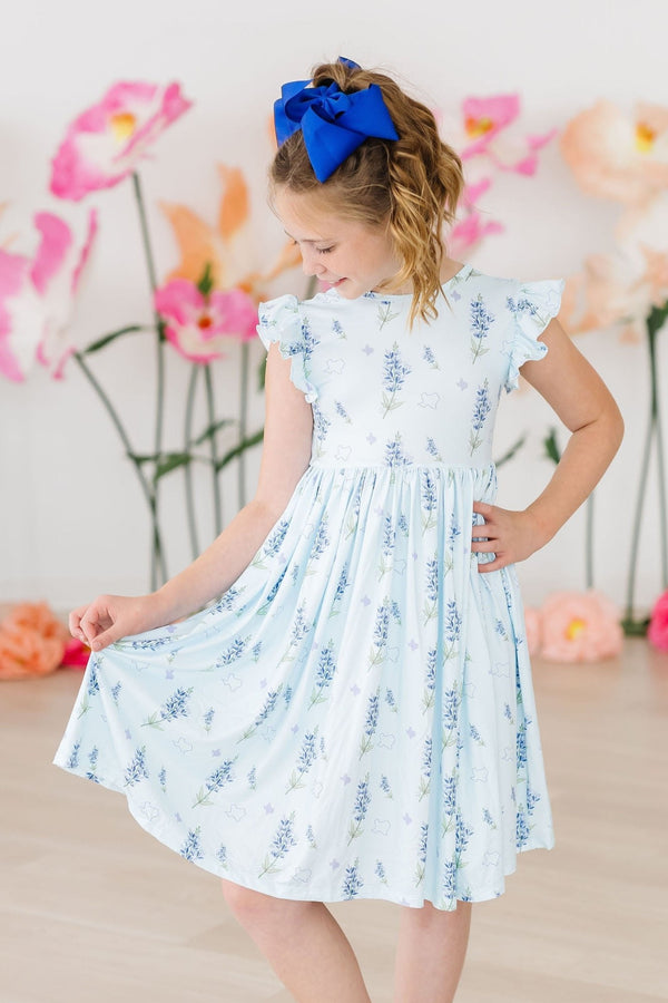 Texas Bluebonnets Flutter Sleeve Twirl Dress for Girls worn by a girl with a bright blue bow.
