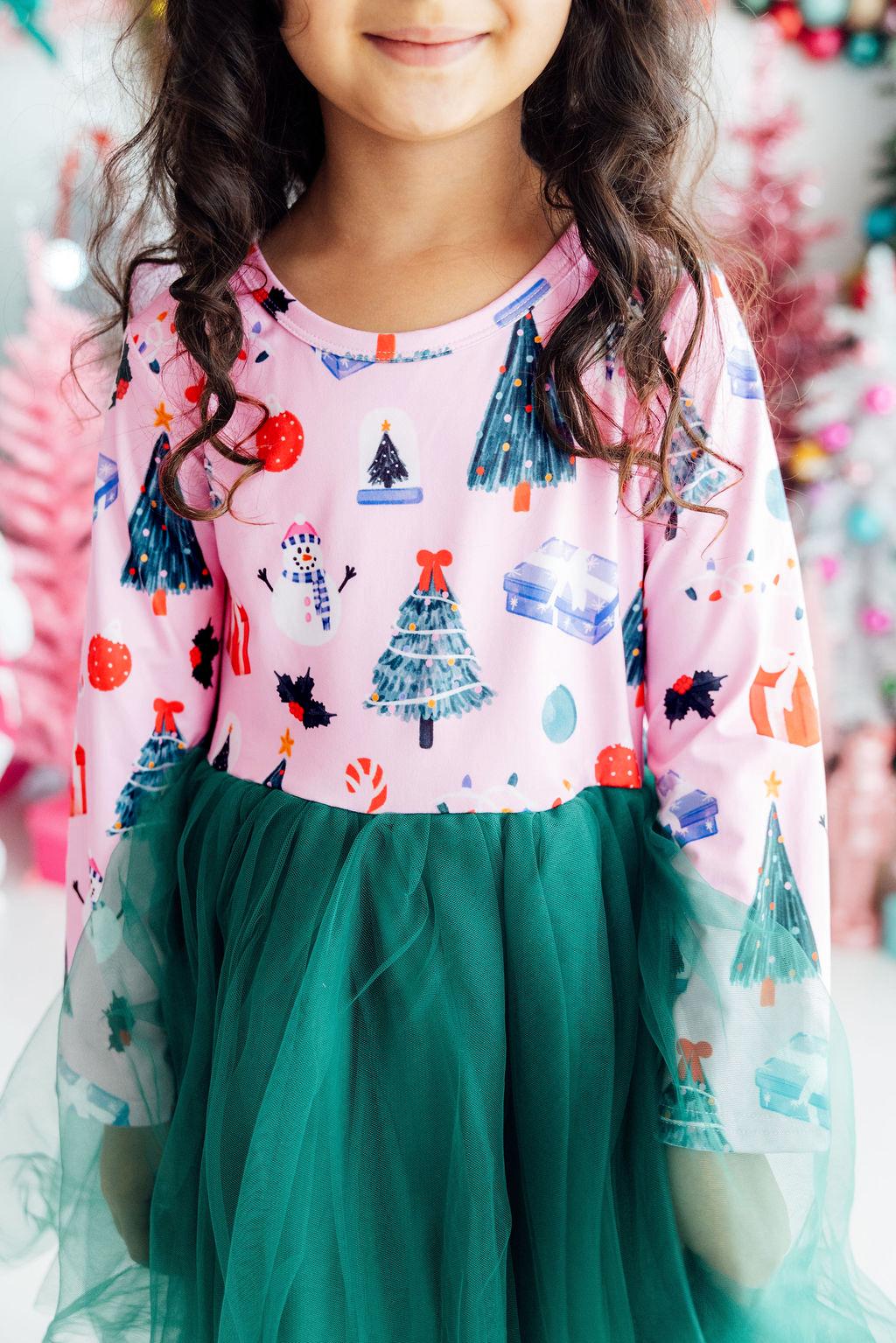 Pink long sleeve tutu dress for girls with Christmas trees, snowmen, and gifts print, featuring a green tulle skirt.