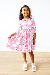 Girl in Unicorn Kitties 3/4 Sleeve Pocket Twirl Dress, pink with unicorn prints and a twirly skirt.