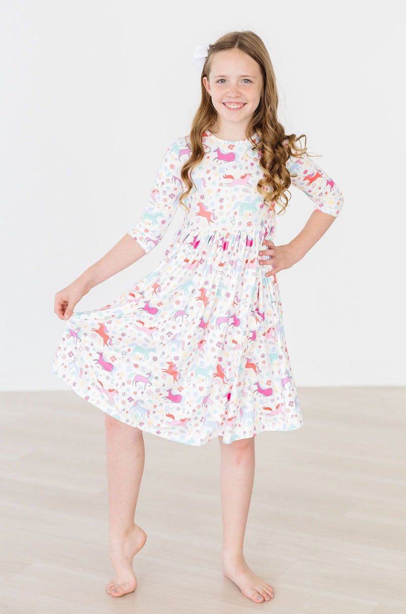 The Unicorn Wish 3/4 Sleeve Pocket Twirl Dress for Girls displayed on a hanger, highlighting its vibrant colors and magical design.