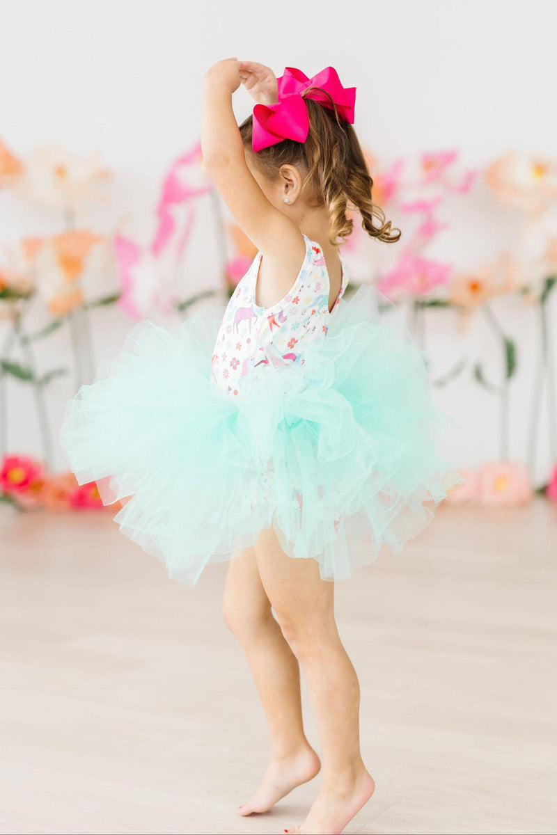 Girl in a Unicorn Wish Tank Tutu Leotard twirling gracefully, showcasing the fluffy tutu and vibrant design, embodying joy and imagination.