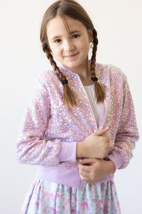 Girl wearing lavender sequin jacket, sparkly kids fashion for photos and twirls.