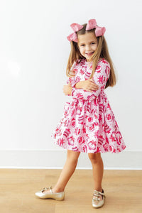 Girl in Vintage Cakes Long Sleeve Pocket Twirl Dress, pink print, twirl-ready full-circle skirt.