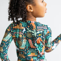 Back view of a person wearing The Second-Skin 2-Piece Long Sleeve Pajama in Wild West hand-drawn print.