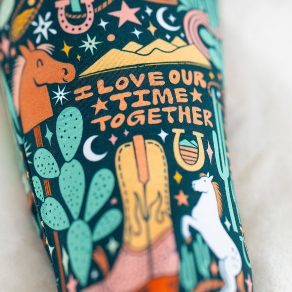 Close-up of a colorful, hand-drawn print on a two-piece long-sleeve pajama fabric.