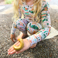 Person wearing cozy two-piece long-sleeve pajama with hand-drawn nature print outdoors.