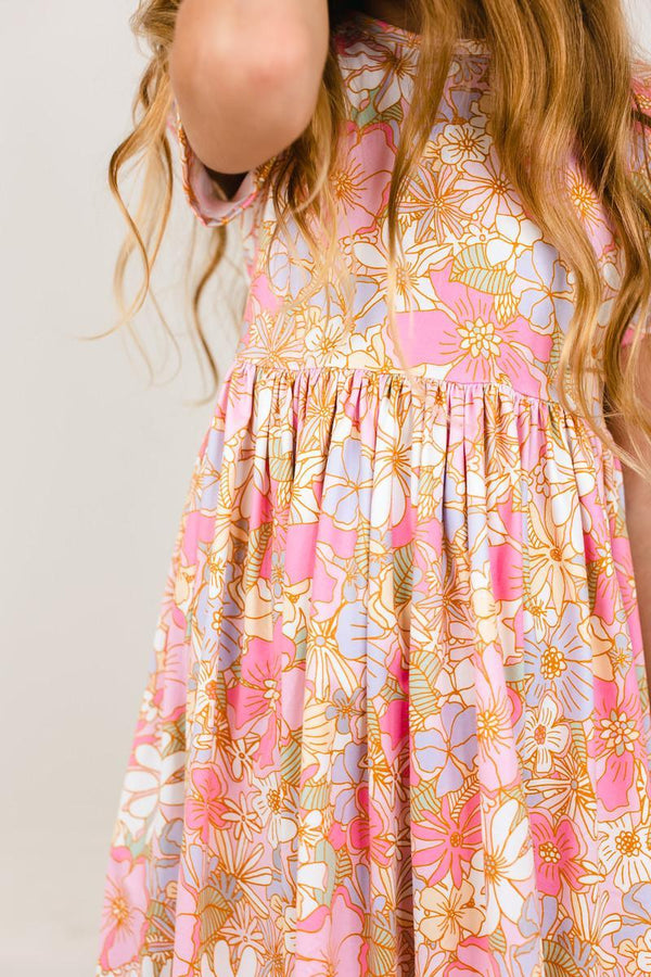 Pink and purple floral short sleeve twirl dress with a gathered waist, designed for comfortable play and easy washing.