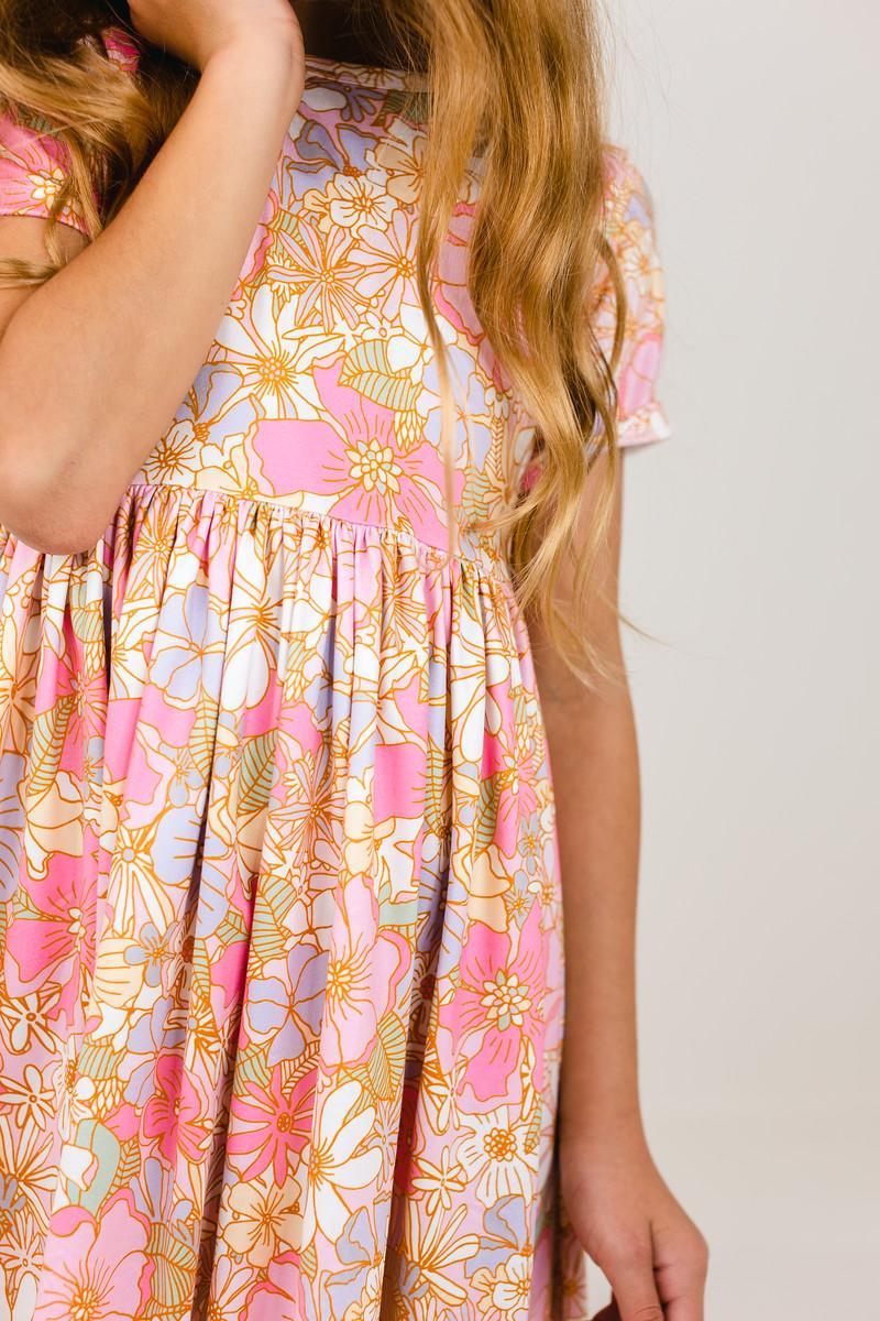 Girls pink floral short sleeve pocket twirl dress with gathered skirt, scoop back, and comfortable fit for school or play.