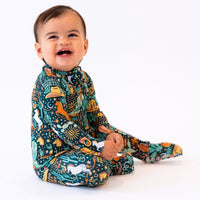 Smiling baby in The Second-Skin Convertible Romper in Wild West print with bold colorful graphics.