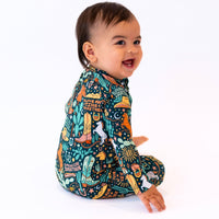 Baby in The Second-Skin Convertible Romper Wild West print, colorful desert-themed design, smiling.