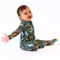 Baby wearing The Second-Skin Convertible Romper Wild West in a colorful animal-print pattern.