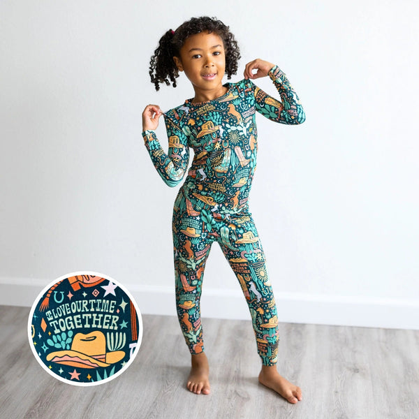 Child wearing The Second-Skin 2-piece long-sleeve pajama in Wild West print.