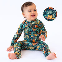 Baby wearing The Second-Skin Convertible Romper in Wild West print with cactus and hat motifs.