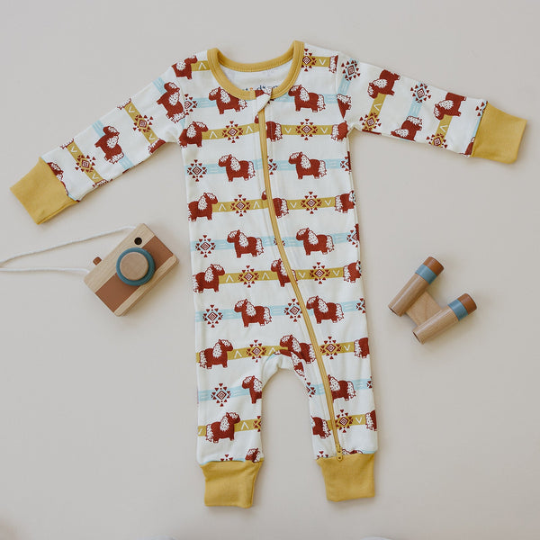 GOTS certified organic cotton zip romper featuring an aztec pony print, yellow cuffs, and front zipper with wooden toys.