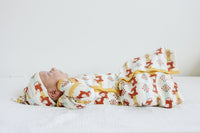 Newborn wearing GOTS certified organic cotton gown and hat with aztec pony print and yellow trim.