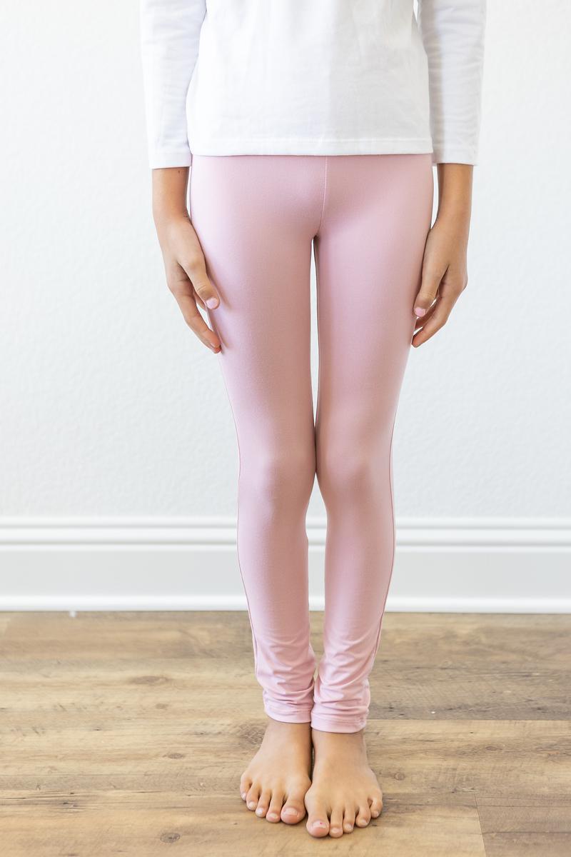 A child wearing Vintage Pink Leggings by Mila & Rose, showcasing a stylish high-waisted design and a slim fit, perfect for layering or solo wear.