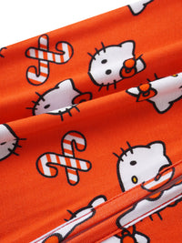 Vibrant orange fabric macro shot with repeating Hello Kitty faces, red bows, and detailed stitching.