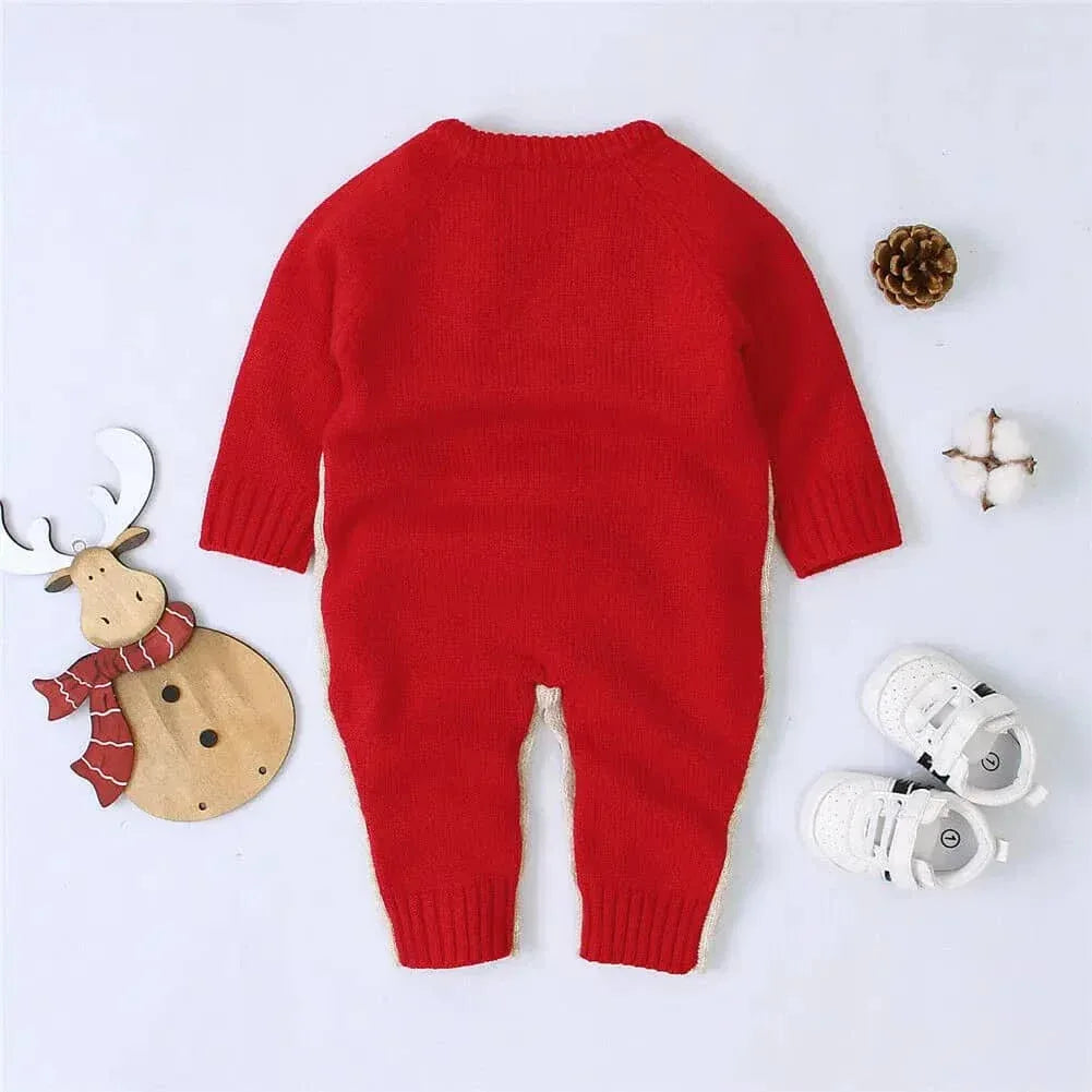 Red reindeer knit romper for babies made of soft knitted material shown with white baby shoes