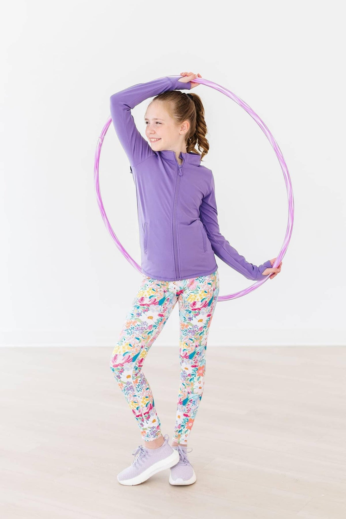Girls white floral active leggings with purple zip-up jacket and pink hula hoop