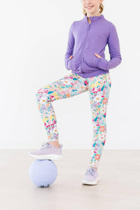 Girls floral print active leggings in bright colors, paired with purple zip-up jacket and sneakers