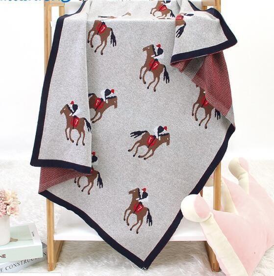 Gray animal knit baby blanket with horse rider pattern, navy border, suitable for newborns and infants