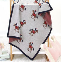 Gray animal knit baby blanket with horse rider pattern, navy border, suitable for newborns and infants