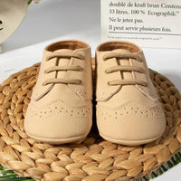 Beige anti-slip baby shoes for boys in size newborn with lace-up design on woven mat