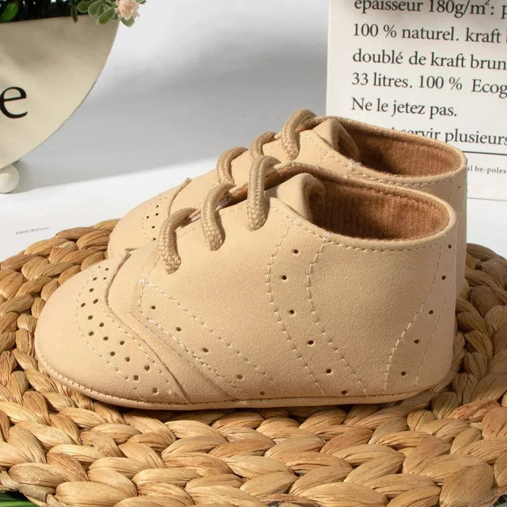 beige anti-slip baby shoes for boys in a small size displayed on a woven mat