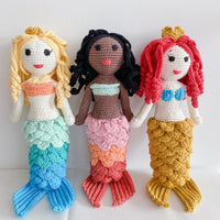 Hand-crocheted blonde mermaid doll with blue-green tail and tiny crown. Soft organic cotton fabric, featuring detailed curls and scales.