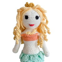 Handmade crochet mermaid doll with blonde curls, gold crown, and teal tail. Soft organic cotton toy for young dreamers.