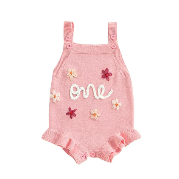Pink baby birthday romper with embroidered flowers and ruffled leg openings for 12 months