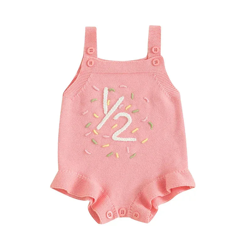 Pink baby birthday romper with embroidered half birthday design and ruffle legs for infants